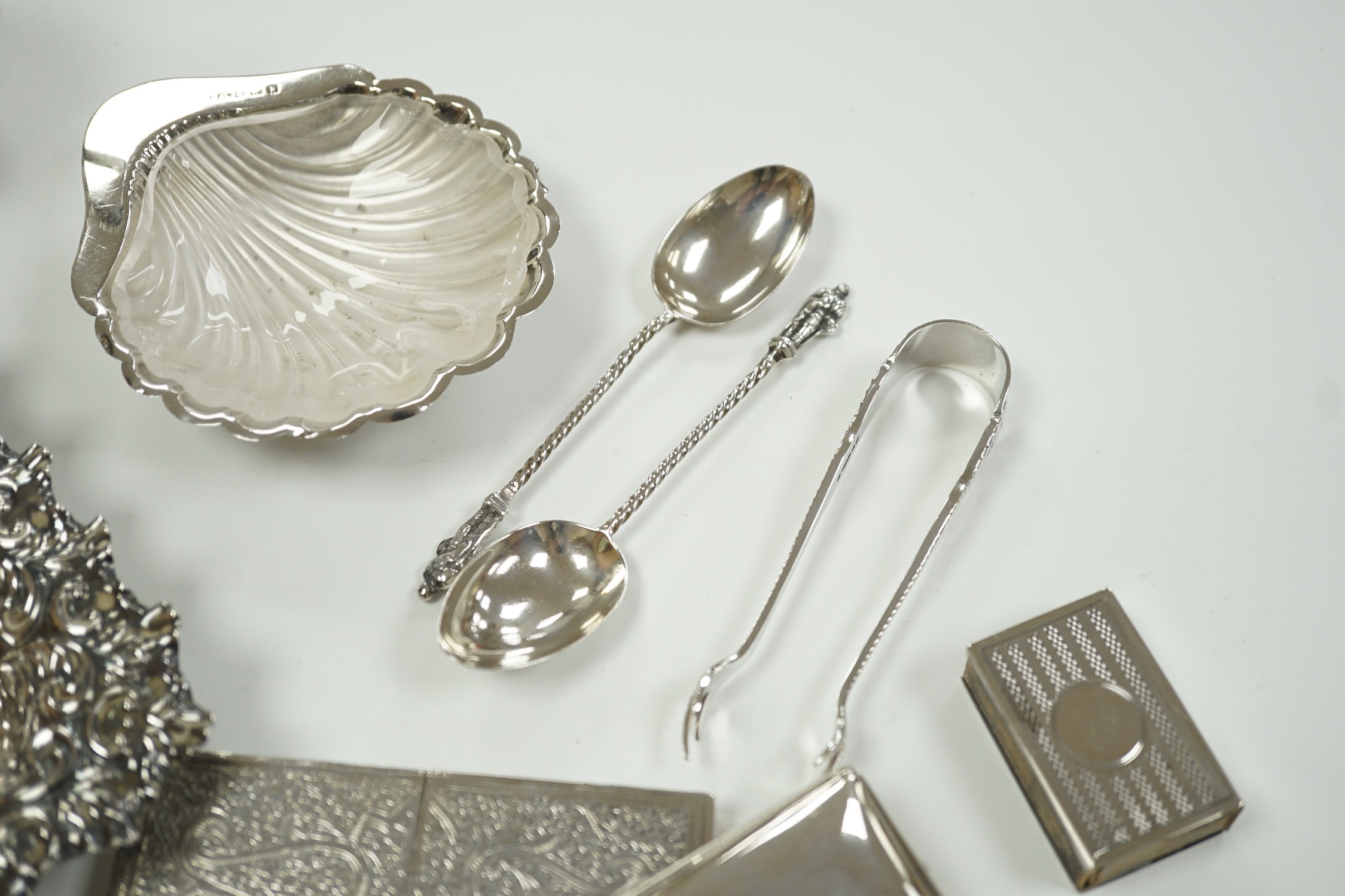 A small group of collectable silver including a repousse bonbon dish, 13.5cm, cigarette case, silver cream jug and sugar bowl, butter shell, vesta case, match sleeve, two apostle teaspoons and a George III curved silver